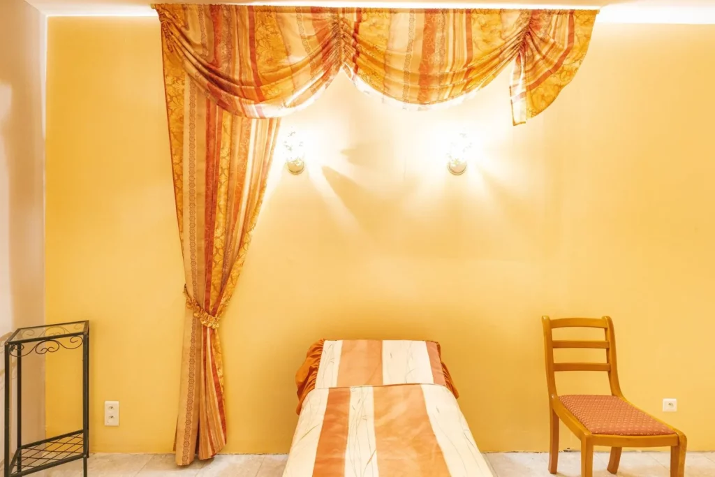 Chambre funéraire chaleureuse avec lit de repos et tentures élégantes.